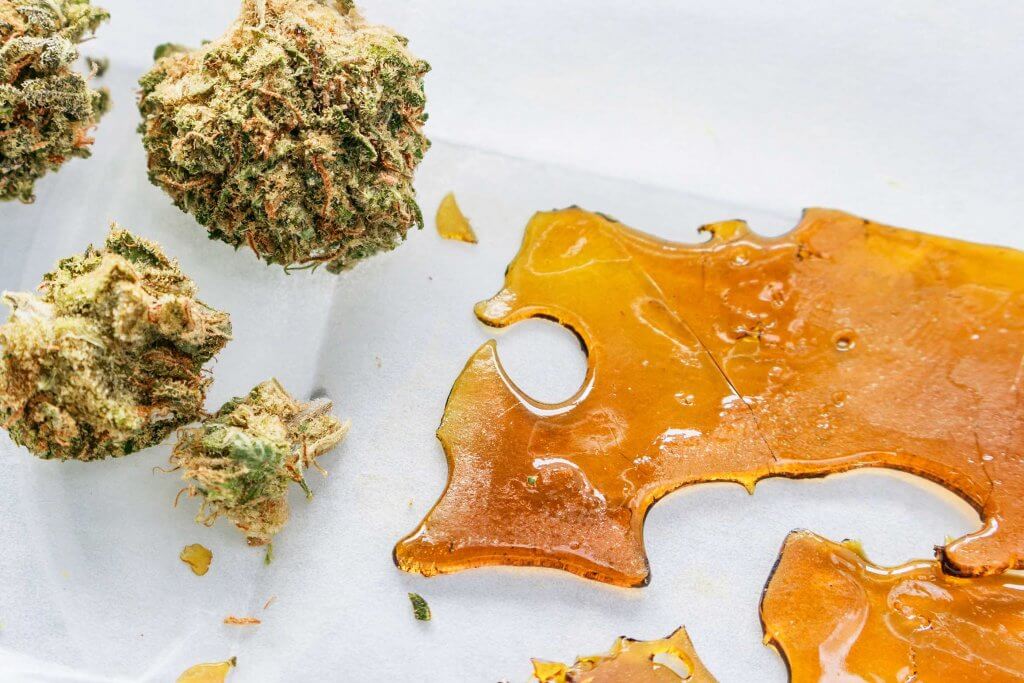 Marijuana buds next to THC concentrate wax